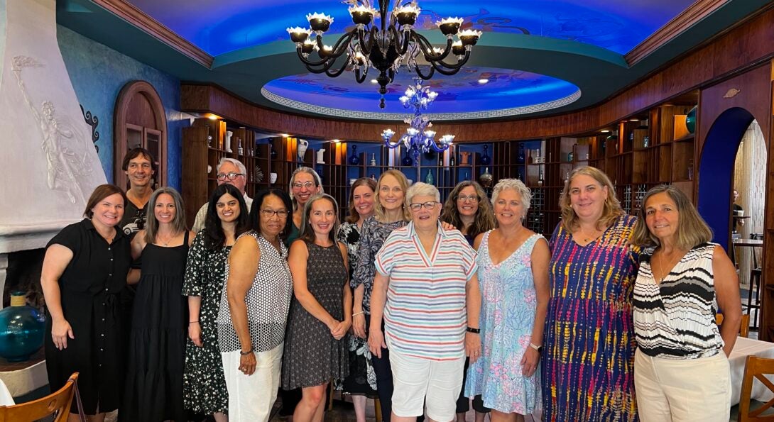 Family, friends, and wo-workers pose for a group photo at a retirement party for two MCMI coaches